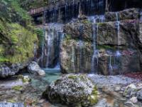 Von der Holztrift Anlage fließt Wasser über Felswände